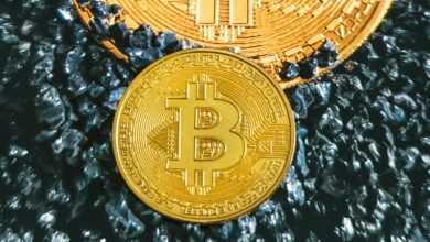 two gold bitcoins sitting on top of each other