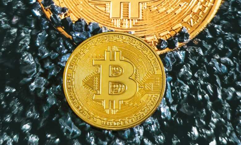 two gold bitcoins sitting on top of each other