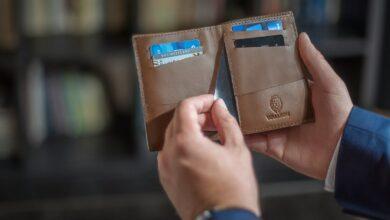 a person holding two wallets in their hands