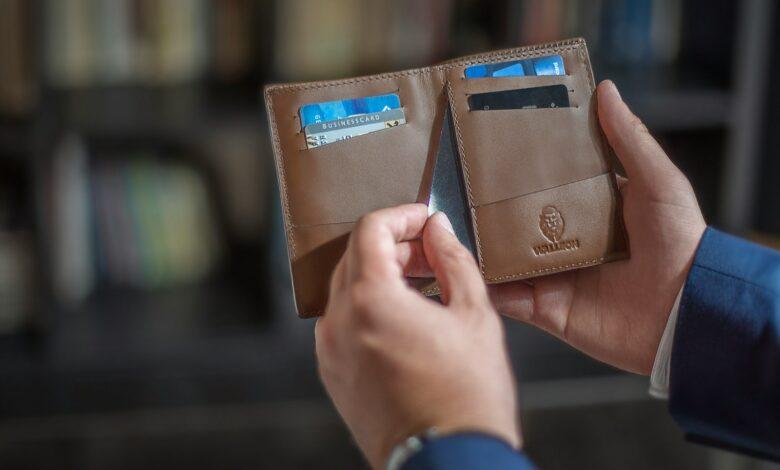 a person holding two wallets in their hands