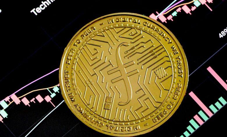 a gold coin sitting on top of a stock chart