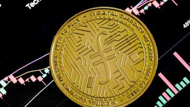 a gold coin sitting on top of a stock chart